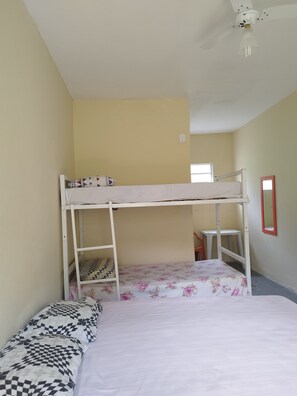 A bunk bed room with a window, a desk, and a mirror. - Suítes Córdoba (Bertioga)
