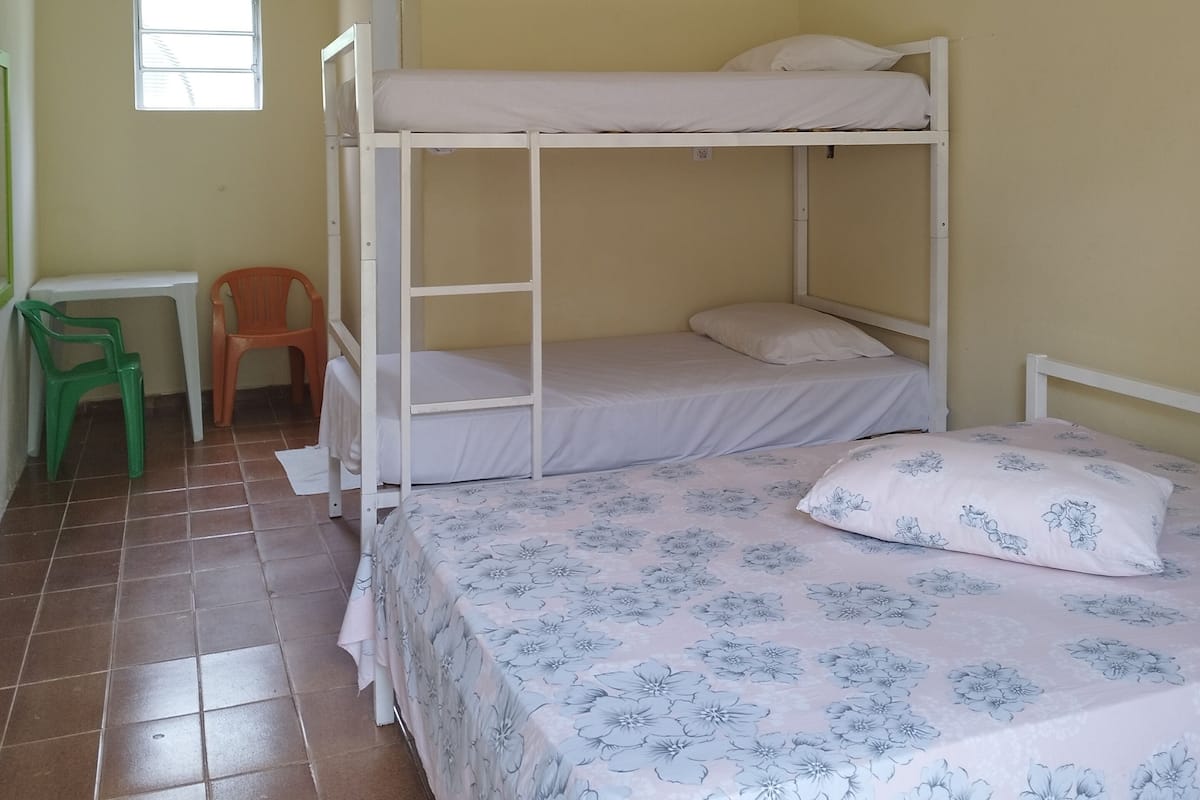 Un dormitorio con literas, un escritorio y una silla.