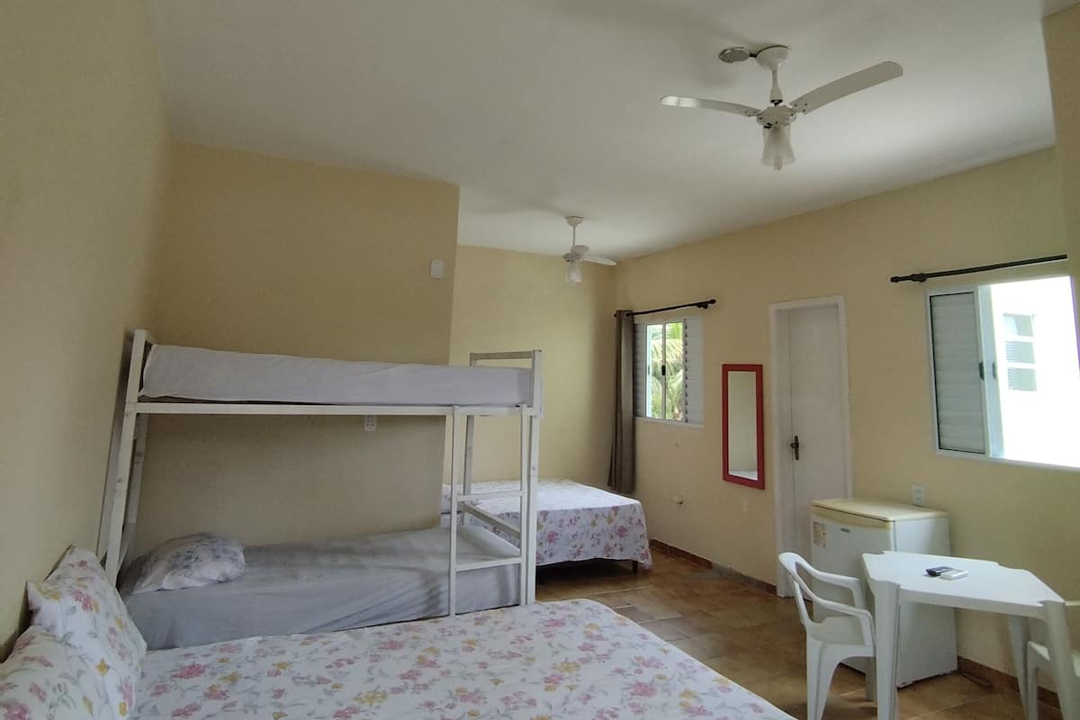 Un dormitorio con literas, un escritorio y una silla.