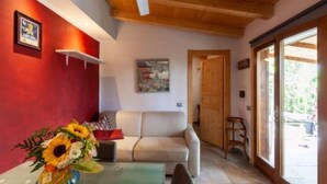 Un salon chaleureux avec un plafond en bois, un canapé beige et une table basse en verre.