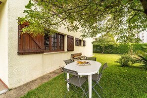 An outdoor dining area with a table and chairs, a bench, and a window with shutters. - Amorosa Villa, 500m from the beach by House and People (Viana do Castelo)