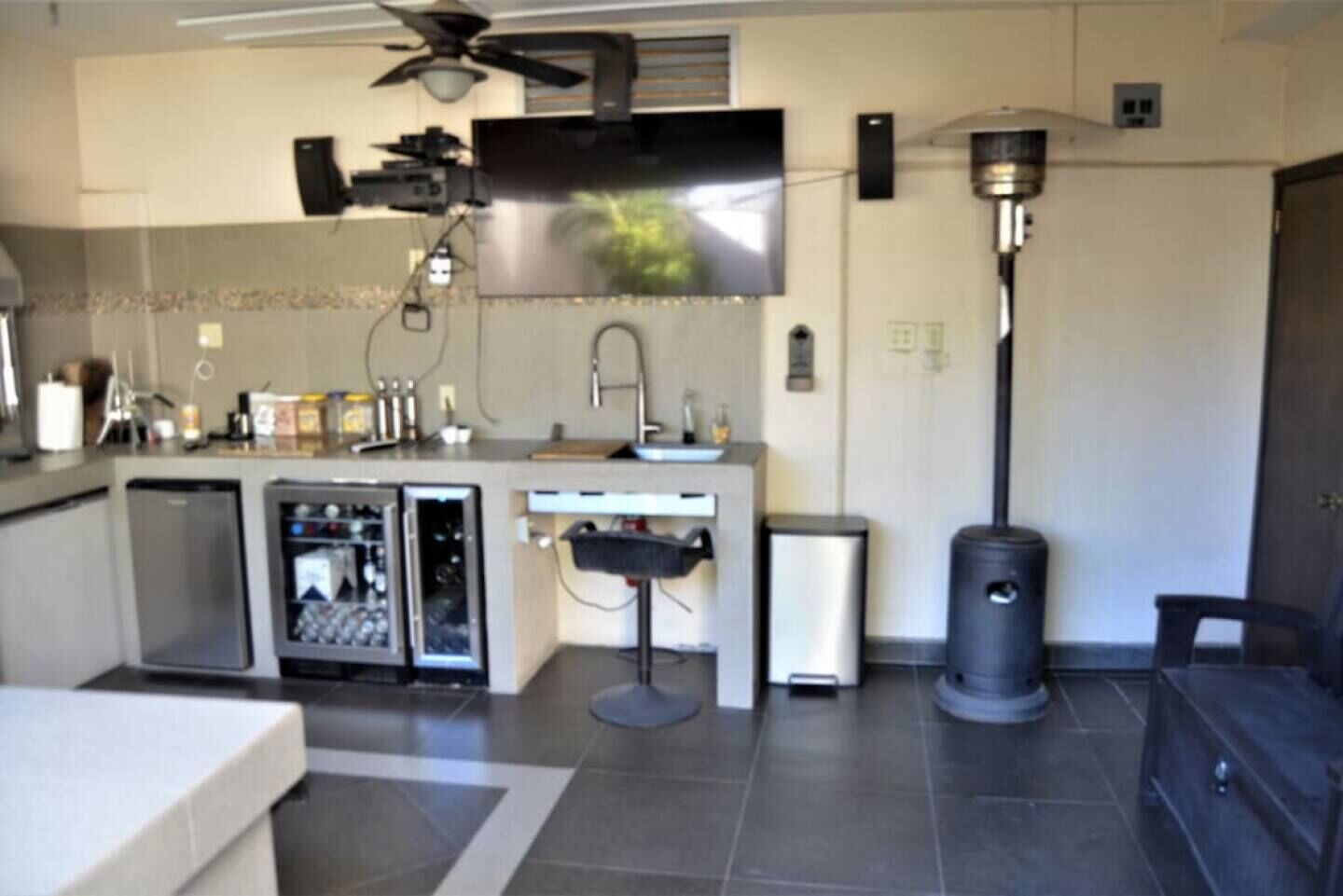 Une cuisine moderne équipée d’un téléviseur à écran plat, d’un ventilateur de plafond et d’une poubelle.