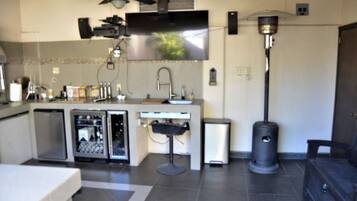 Une cuisine moderne équipée d’un téléviseur à écran plat, d’un ventilateur de plafond et d’une poubelle.
