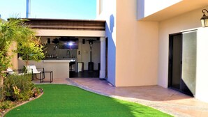 A modern outdoor kitchen area with a bar, seating, and a well-maintained lawn. - Dive into the relaxed elegance of our 4-bedroom haven in Zona Dorada, Mexicali's prestigious district, combining comfort, security, and luxury. Ideally nested near bustling plazas, trendy restaurants, and lively casinos, our property is perfect (Mexicali)