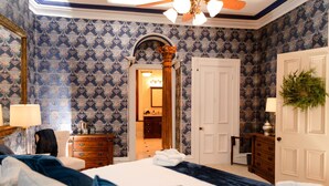 Un dormitorio con una cama grande, cómoda de madera y un espejo.