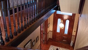 Una imponente escalera con barandilla de madera y un rellano alfombrado.