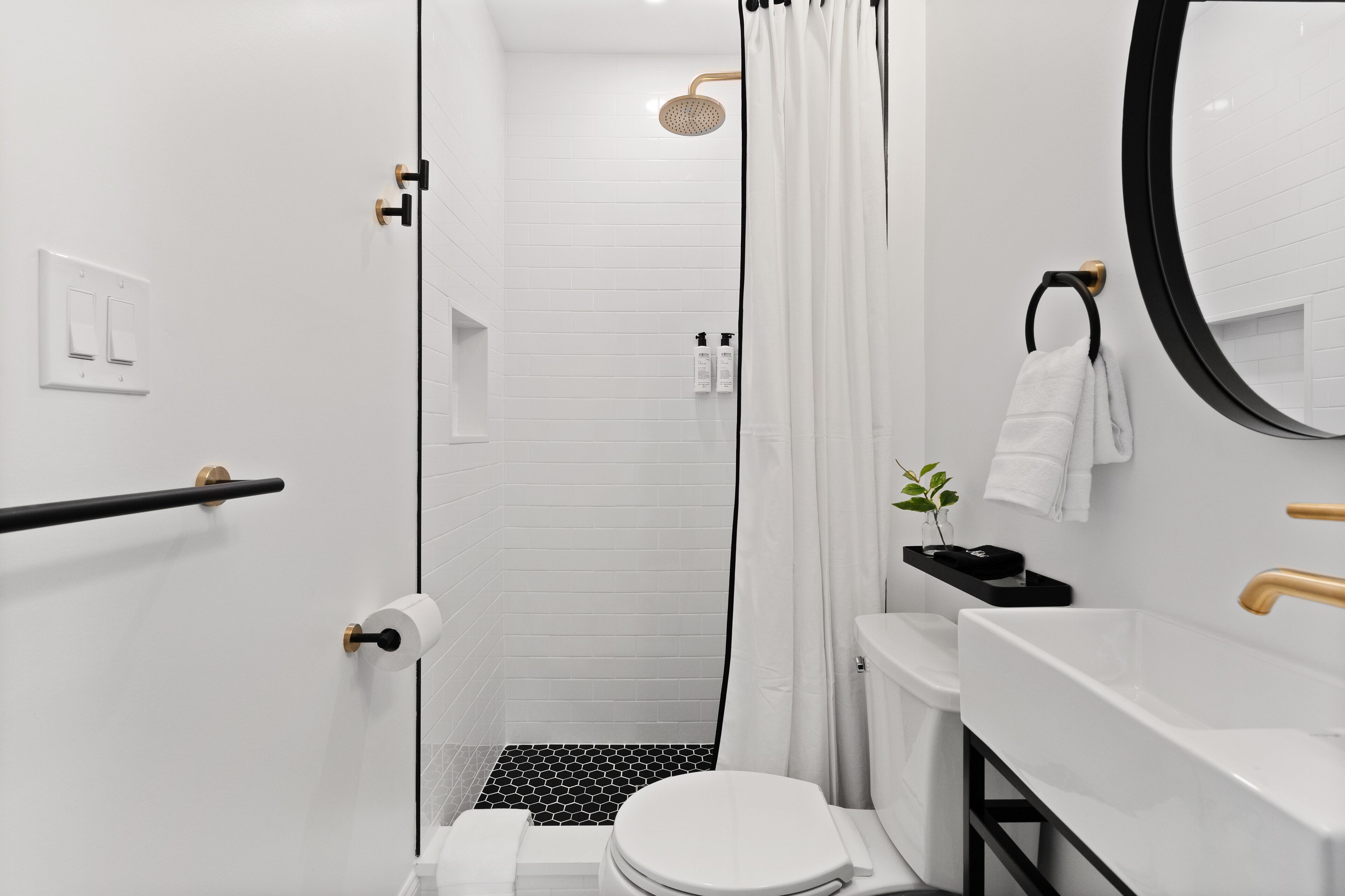 Een moderne badkamer met douche, toilet en wastafel.