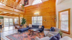A spacious living room with a high ceiling, wooden walls, and large windows. - Family-Friendly Cabin By Golf Course & Marina (Holiday Island)