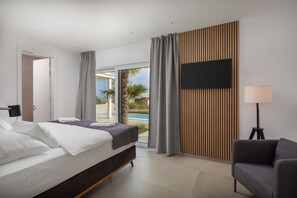 Une chambre d’hôtel moderne équipée d’un lit, d’un bureau, d’une chaise et d’un téléviseur.