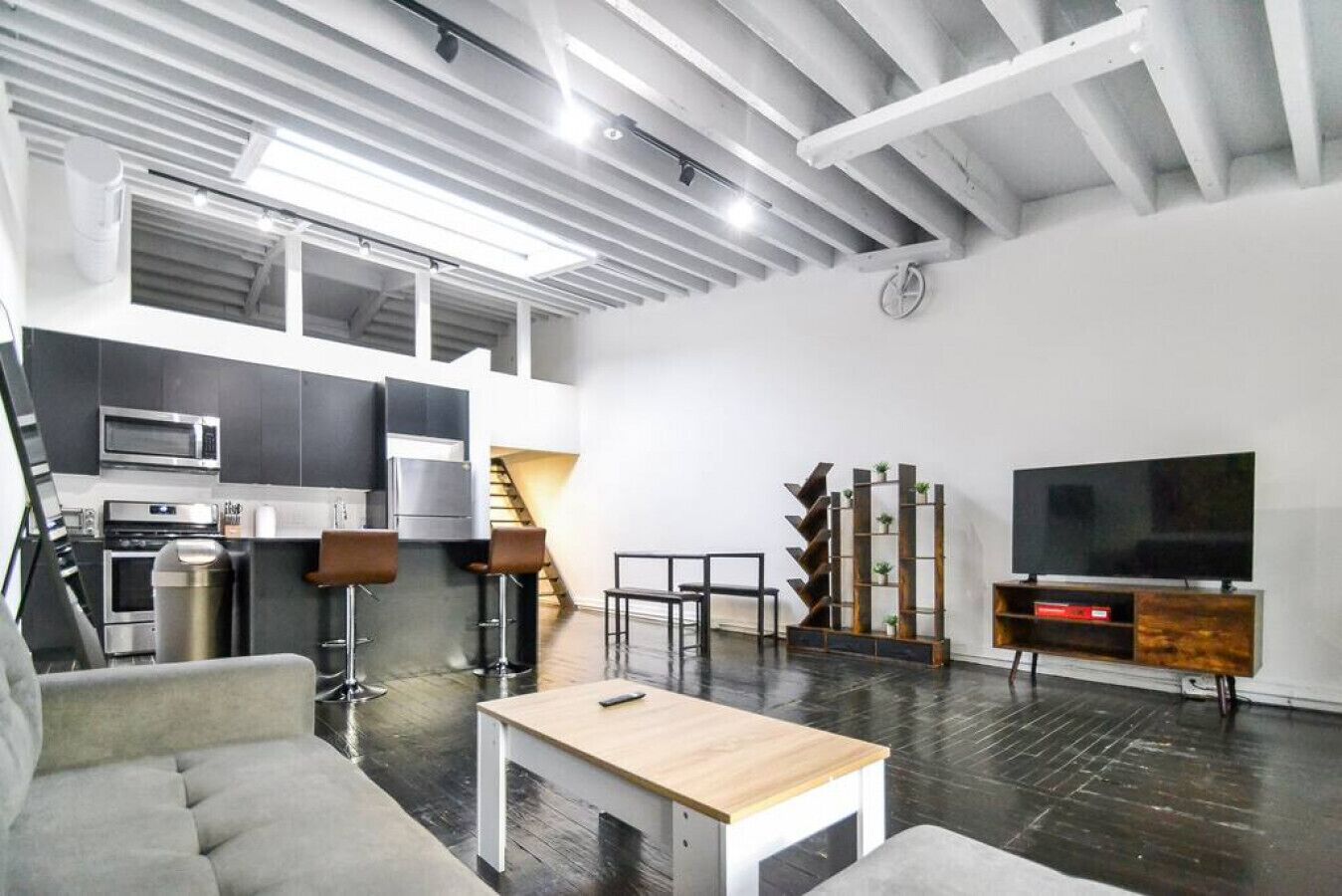 A modern apartment with a kitchen, dining area, and living room.