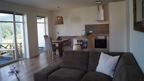 Een moderne woonkamer met een bank en een eethoek.