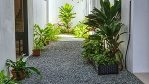 Un étroit sentier bordé de plantes en pot qui mène à un escalier.