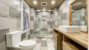 Een douche, handdoeken, zeep, toiletpapier