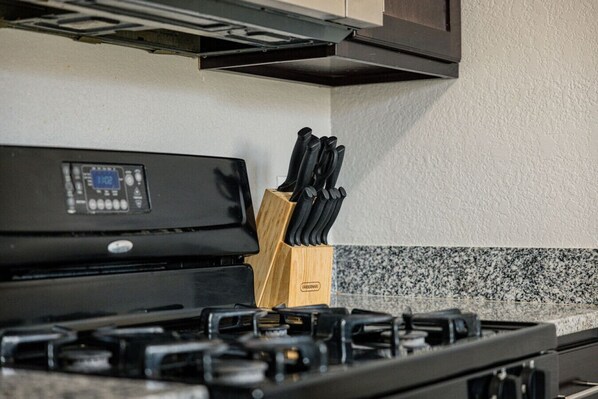 A kitchen with a stove, a digital control panel, and a knife block. - Craftsman Charm Comfort 3BDR (El Paso)