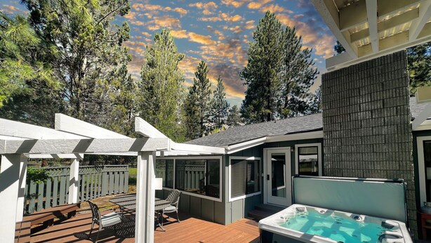 A backyard with a hot tub, wooden deck, and a pergola. - Modern Tollgate Home - HOT TUB, Half Acre Lot (Sisters)