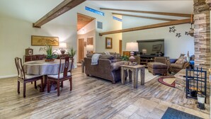 A spacious living area with a dining table, sofas, and a fireplace. - Modern Tollgate Home - HOT TUB, Half Acre Lot (Sisters)