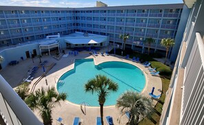 A hotel with a central pool surrounded by lounge chairs and palm trees. - RENOVATED LUXURY BEACH VILLA,Ocean view,3 bdrms each with smart tv and king bed (Hilton Head Island)