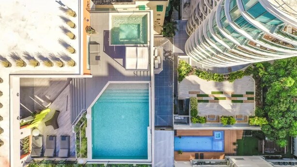 Un hôtel moderne doté d’une piscine sur le toit, d’une autre piscine séparée et d’un magnifique jardin.