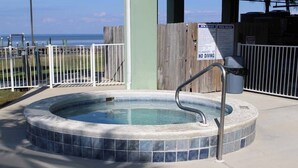 A hot tub with a tiled edge, a metal ladder, and a sign prohibiting diving.