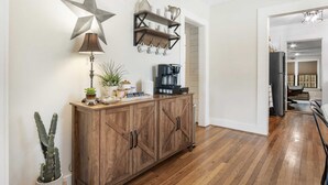 Een keuken met houten kastjes, een ster decoratie, een koffiezetapparaat en een plank met bekers.
