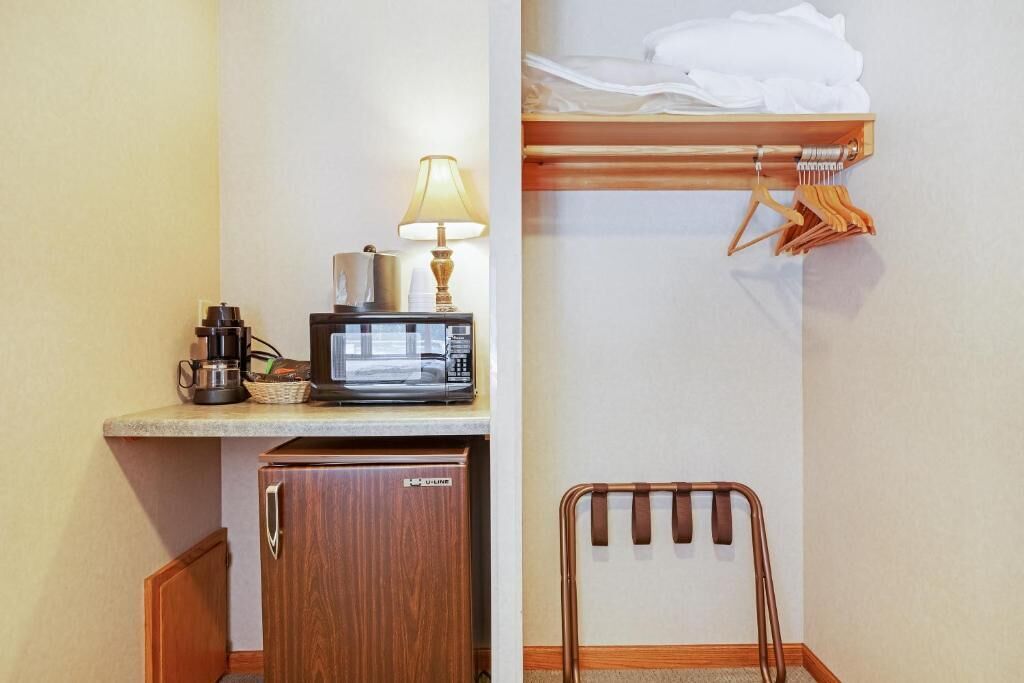 A kitchenette with a microwave, coffee maker, and a small cabinet.