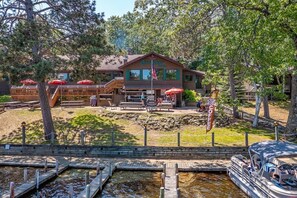 A lodge with outdoor seating, a dock, and a flag indicating 'Fresh Hot Coffee'. - Chanticleer Inn (Eagle River)