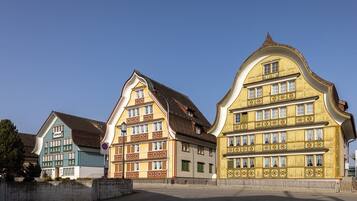 A row of traditional European buildings with distinct architectural styles, including gabled roofs and decorative facades.