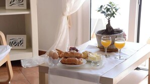 A breakfast table with croissants, eggs, and orange juice. - Maisonette Near Beach & City Center (Heraklion)