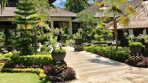 A resort with thatched-roof buildings, a paved walkway, and lush tropical landscaping. - "nusa Dua Luxury 2 Bedroom Apartment" (Nusa Dua)