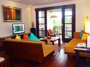 Relax in this inviting living area with a sofa set, TV, and sliding glass door leading to an outdoor dining space.