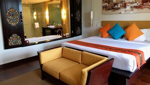 A hotel room with a large bed, a sofa, a bathroom with a sink and mirror, and a painting on the wall. - "nusa Dua Luxury 2 Bedroom Apartment" (Nusa Dua)