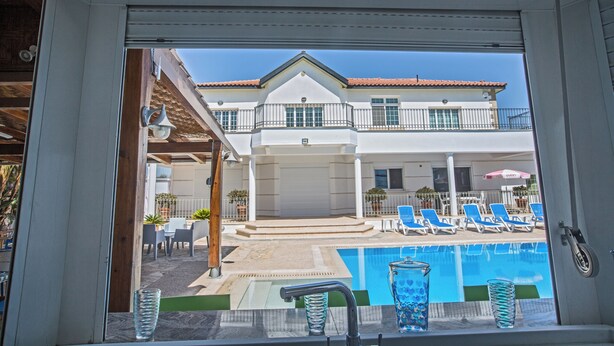 A view of a swimming pool with lounge chairs and a building in the background. - Papas Family Villa With Private Pool Wheelchair Accessible (Paralimni)