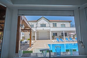 A view of a swimming pool with lounge chairs and a building in the background. - Papas Family Villa With Private Pool Wheelchair Accessible (Paralimni)