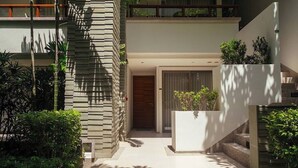 A modern building with a stone facade, a wooden door, and a staircase leading to an upper level.