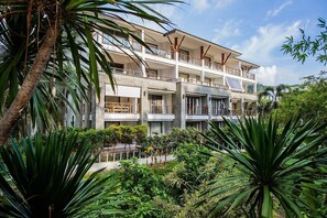 A multi-story hotel with balconies, surrounded by lush greenery. - Beachfront 2br Home With Private Plunge Pool on Stunning Naithon Beach 3 (Sa Khu)