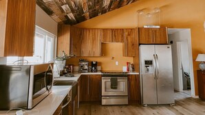 A kitchen with wooden cabinets, a stainless steel refrigerator, and a microwave. - Love Casa Pool Fire Pit Close To Wineries (Temecula)