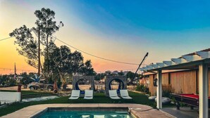 A swimming pool with lounge chairs, a pergola, and a view of the sunset. - Love Casa Pool Fire Pit Close To Wineries (Temecula)