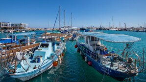 A marina with various boats docked, a building with a sign, and a clear blue sky. - Sanders Crystal 2 - Cute 1-bdr Apt With Shared Rooftop (Limassol)