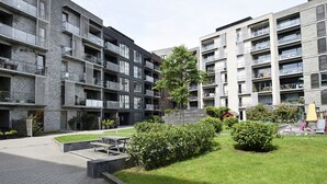 A modern apartment complex with multiple balconies, a central courtyard with a picnic table, and a playground area. - Modern Apartment in Copenhagen Sluseholmen With a Marvellous View (Copenhagen)