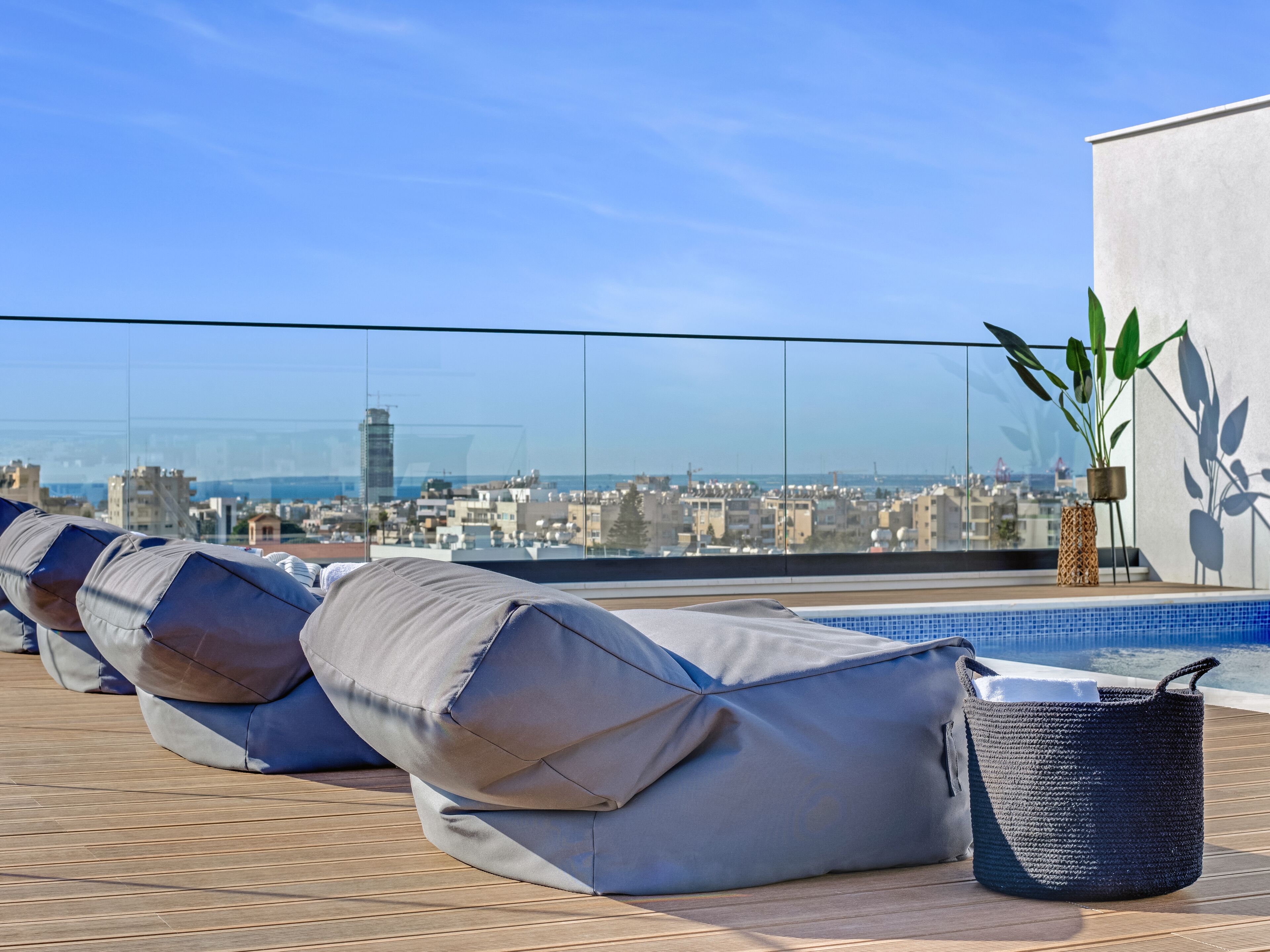 Eine Dachterrasse mit Pool, Liegestühlen und einem Topfpflanzen.