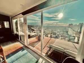 A room with large sliding glass doors leading to a deck with a view of a town and hills. - Mountain View Ranch Pool Hot Tub 15guests (Temecula)