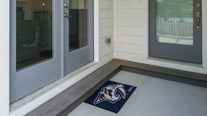 A house entrance with a sliding glass door, a front door, and a porch with a doormat.