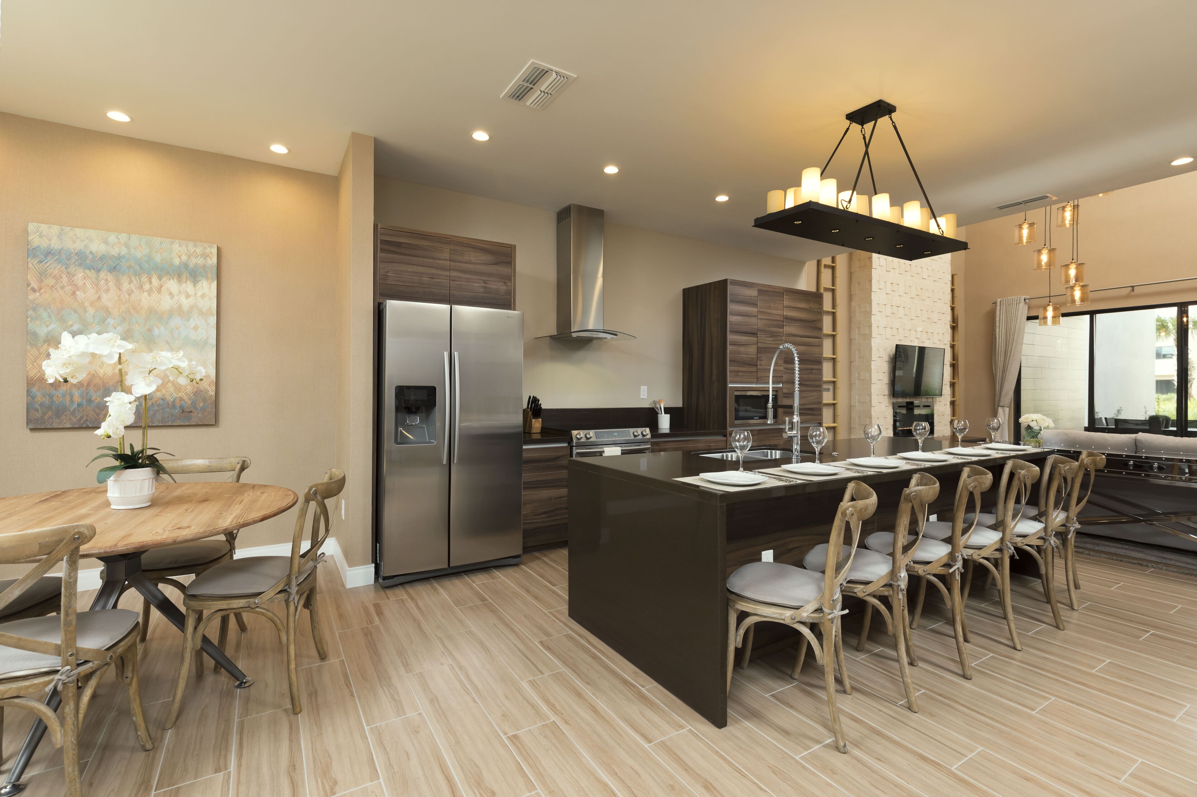 Una cocina moderna con una isla central, electrodomésticos de acero inoxidable y un comedor con sillas de madera.