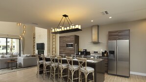 A modern kitchen with a central island, stainless steel appliances, and a dining area with chairs. - 5 Miles to Disney/Gorgeous Home/Wi-Fi/Parking/BBQ Grill/Family Friendly (Kissimmee)
