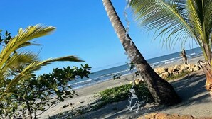 A beach with palm trees, a clear sky, and a pool. - CASA ORIGEN BOUTIQUE (San Bernardo del Viento)