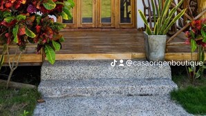 A wooden building with a thatched roof, a wooden balcony, and a set of double doors. - CASA ORIGEN BOUTIQUE (San Bernardo del Viento)