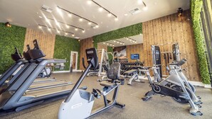Et fitnesscenter med løbebånd, crosstrainere og træningsudstyr.