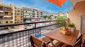A balcony with a table, chairs, and a fruit basket. - Home2Book CrisSol Los Cristianos Pool Retreat (Los Cristianos)