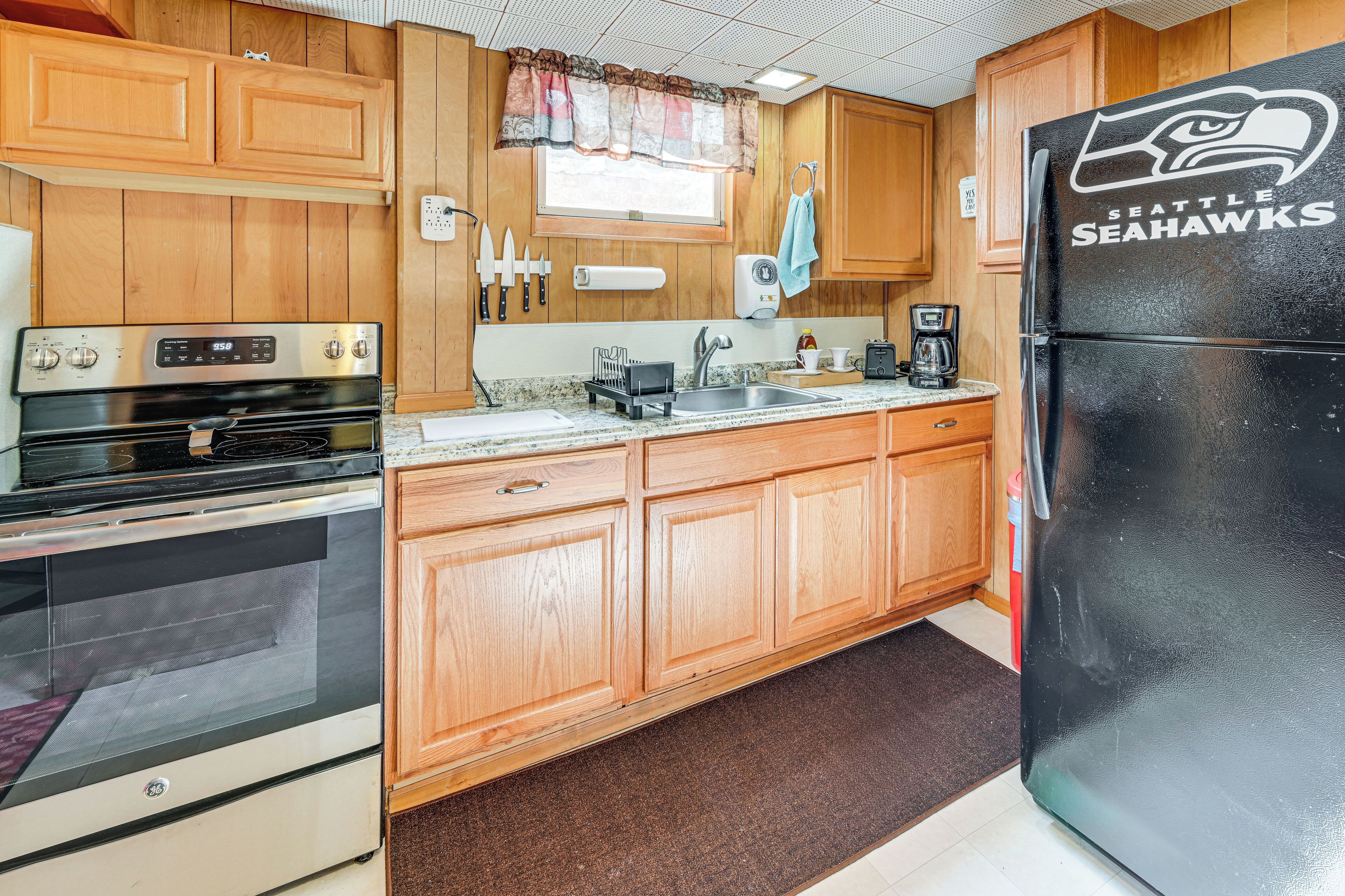 A kitchen with wooden cabinets, a stainless steel refrigerator, and a GE oven.