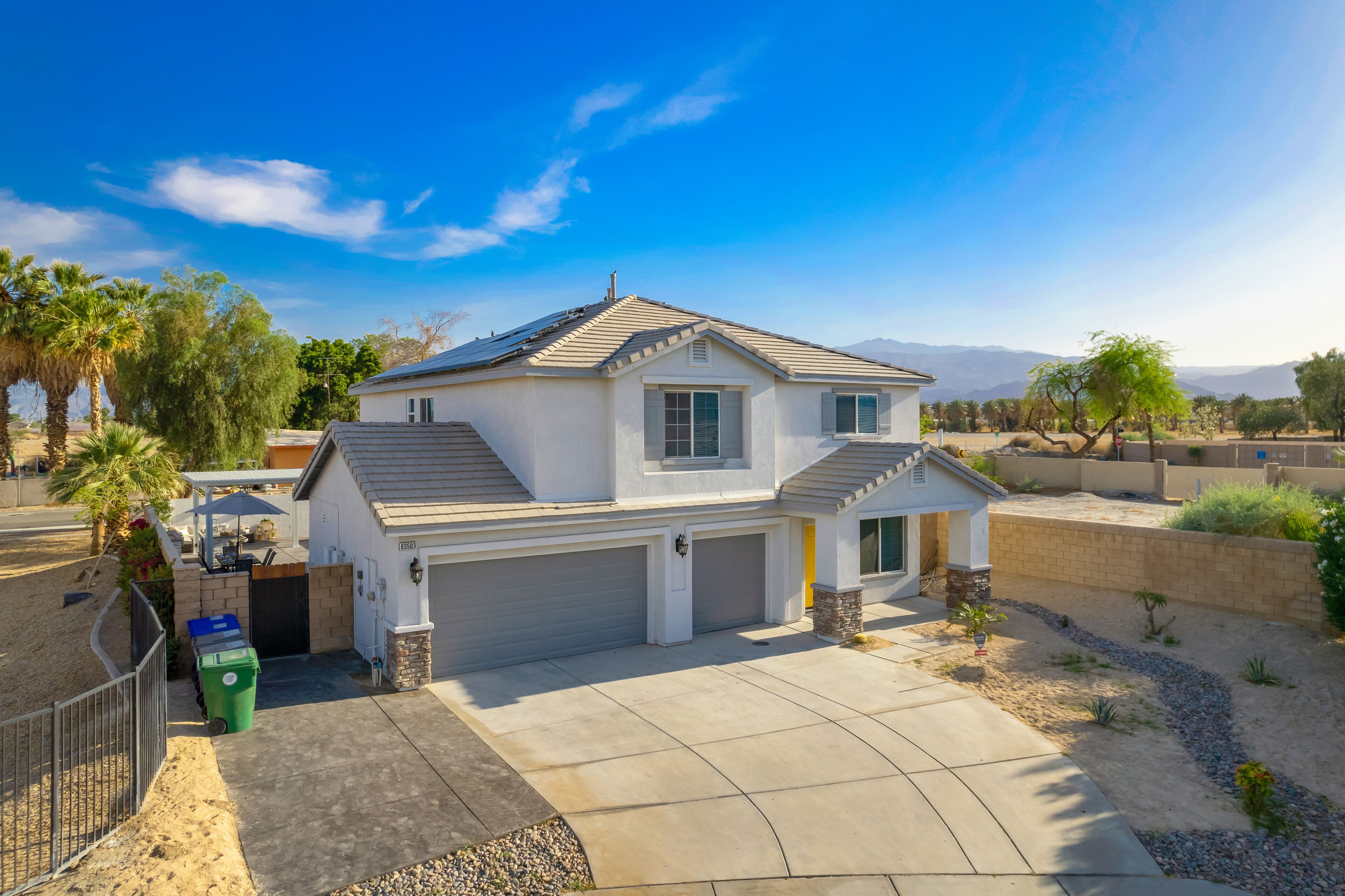 A single-story house with a garage, solar panels, and a well-maintained lawn.